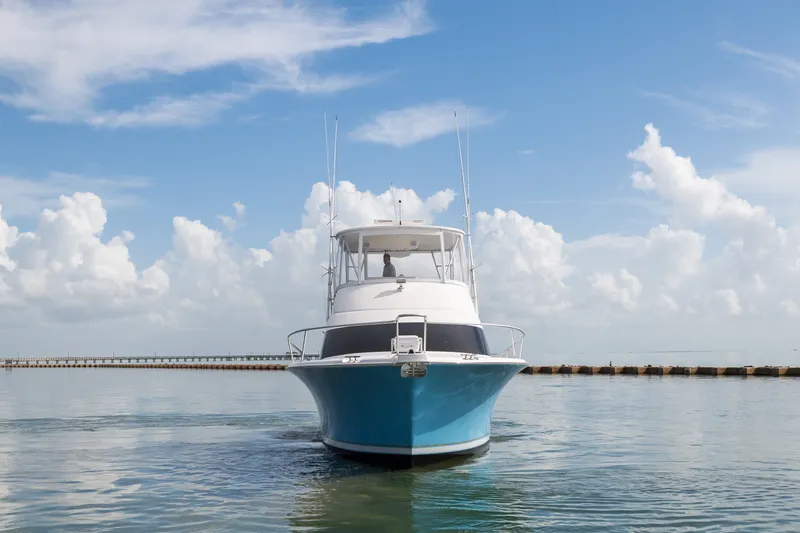 Slide: The Image of 2005 Luhrs 41 Convertible yacht on calm water under a clear blue sky. - 5