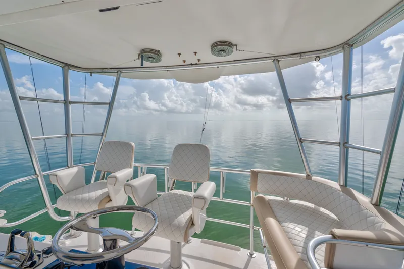 Slide: The Image of 2005 Luhrs 41 Convertible yacht helm with ocean view and white seating. - 23