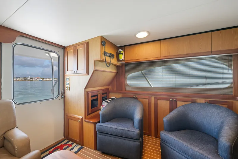 Slide: The Image of Interior of 2005 Luhrs 41 Convertible yacht with blue chairs and wooden cabinetry. - 9