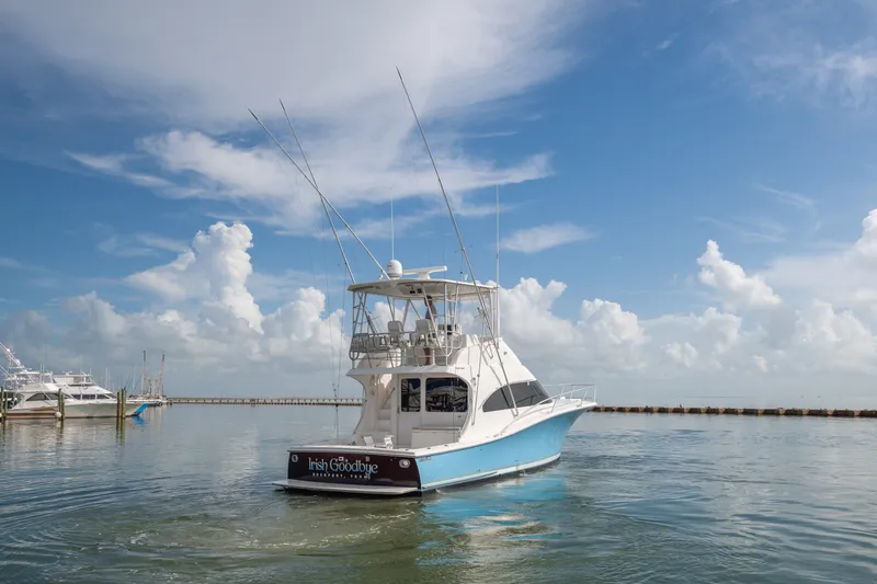 Slide: The Image of 2005 Luhrs 41 Convertible yacht on calm waters under a clear blue sky. - 2