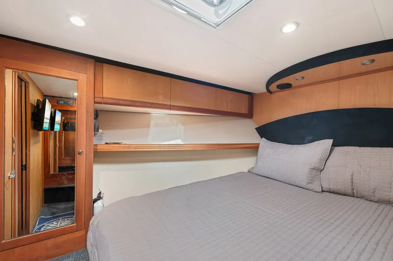 Slide: The Image of Luxurious cabin interior of 2005 Luhrs 41 Convertible yacht with cozy bedding and wood accents. - 17