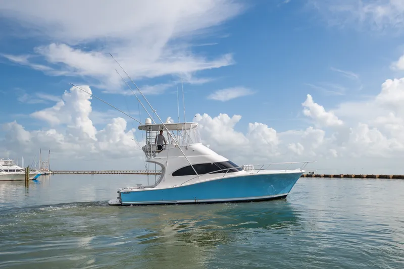 Slide: The Image of 2005 Luhrs 41 Convertible yacht cruising on calm waters under a clear blue sky. - 1