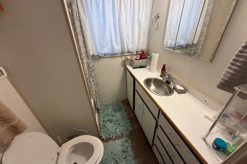 Slide: The Image of Compact bathroom with sink, toilet, and storage in a 2003 Gibson 5500 SERIES. - 6