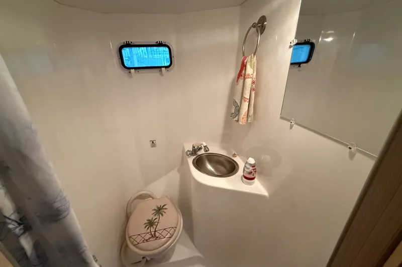 Slide: The Image of Compact bathroom in a 2003 Gibson 5500 SERIES boat, featuring a sink and toilet. - 11