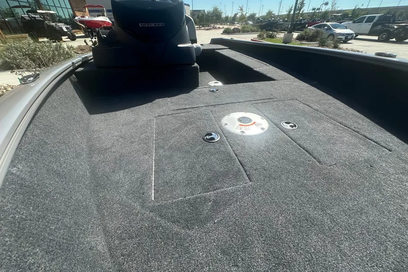Slide: The Image of 2027 Tracker Super Guide V-16 SC boat interior with carpeted deck and storage compartments. - 15