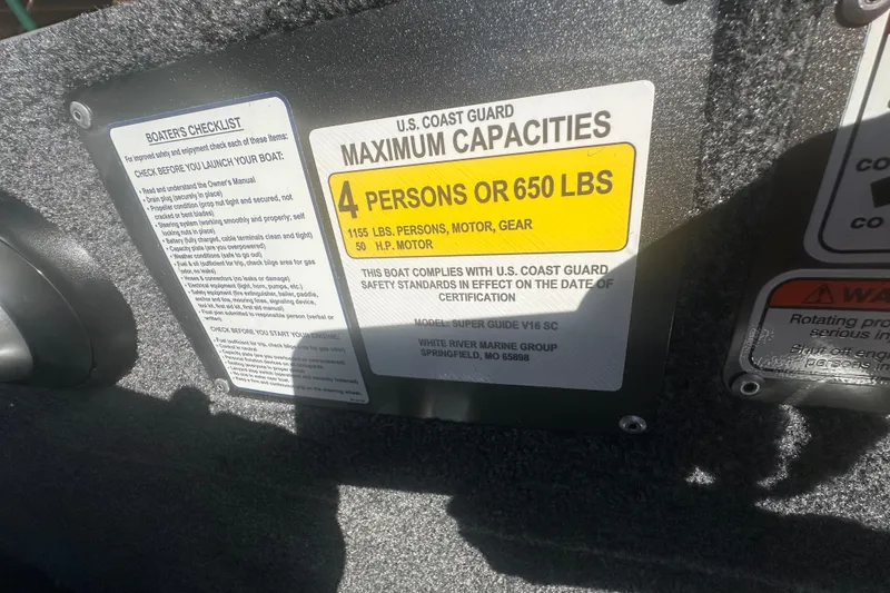 Slide: The Image of U.S. Coast Guard capacity label on 2027 Tracker Super Guide V-16 SC boat, 4 persons or 650 lbs. - 18