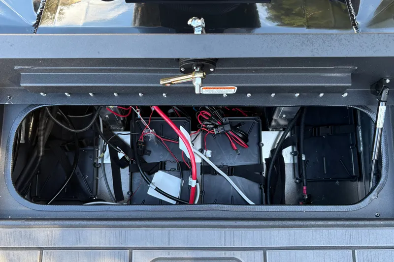 Slide: The Image of Battery compartment of 2027 Tracker Savage 215 with visible wiring and components. - 26