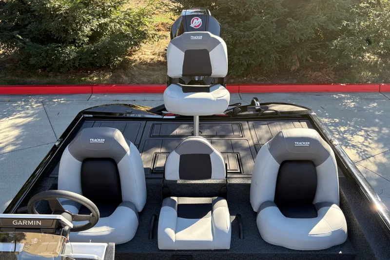 Slide: The Image of 2027 Tracker Savage 215 boat interior with three cushioned seats and Garmin equipment. - 20