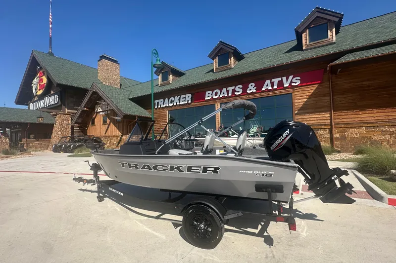 The Image of 2027 Tracker Pro Guide V-16 WT boat displayed outside a Tracker Boats & ATVs store. - 0