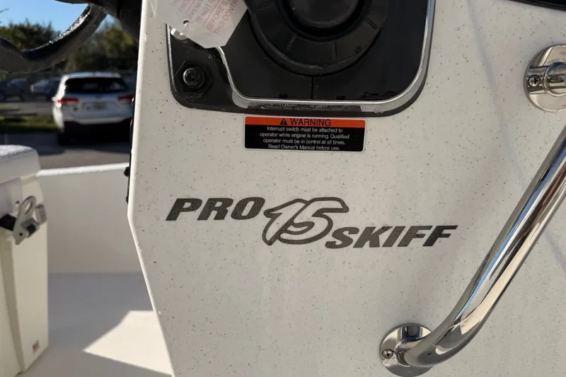 Slide: The Image of 2027 Mako Pro Skiff 15 CC boat console with warning label and steering wheel. - 7