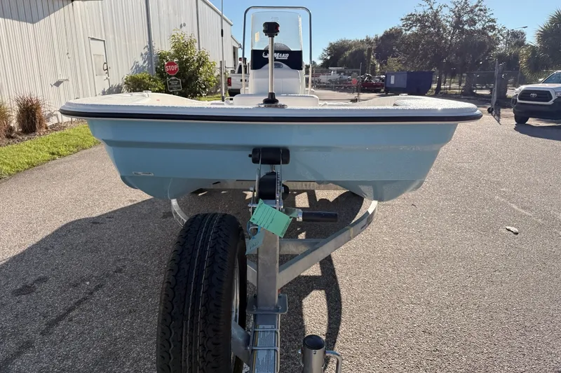 Slide: The Image of 2027 Mako Pro Skiff 15 CC on trailer, parked outdoors in sunny setting. - 4