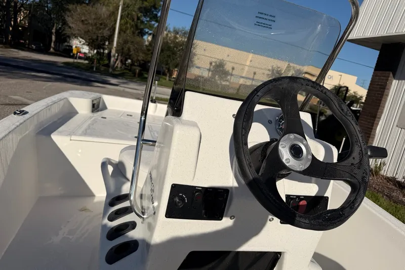 Slide: The Image of 2027 Mako Pro Skiff 15 CC boat interior with steering wheel and console. - 11