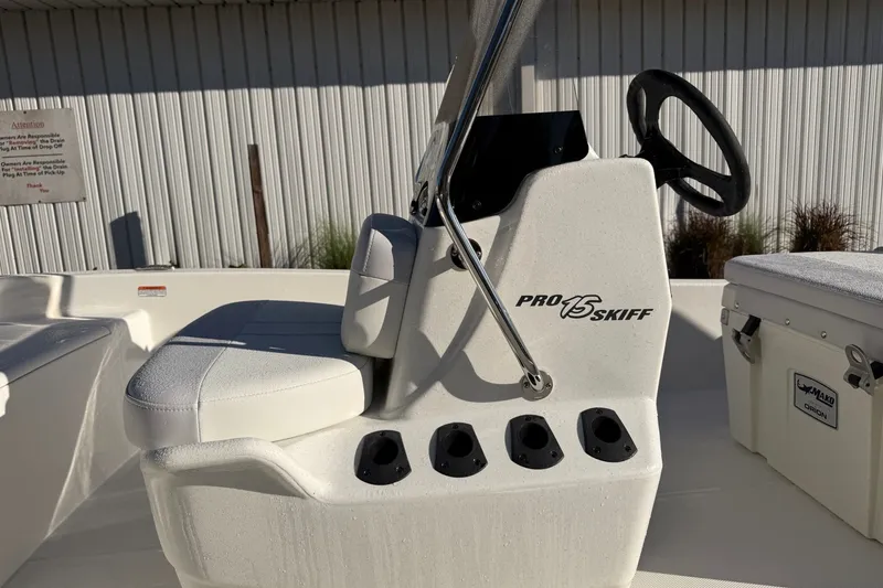 Slide: The Image of 2027 Mako Pro Skiff 15 CC boat interior with steering console and seating. - 12