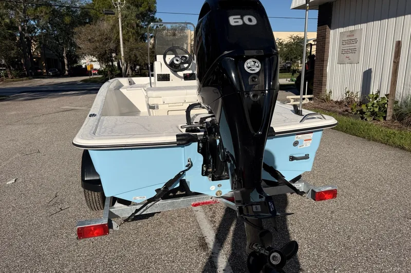 Slide: The Image of 2027 Mako Pro Skiff 15 CC boat with 60 HP engine on a trailer. - 5