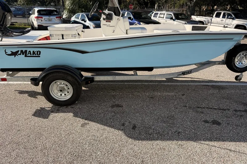 Slide: The Image of 2027 Mako Pro Skiff 15 CC boat on trailer, parked in a lot. - 1