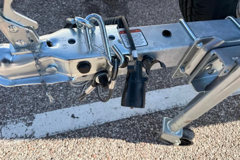 Slide: The Image of Trailer hitch of a 2027 Mako Pro Skiff 15 CC, showing safety chains and wiring. - 59