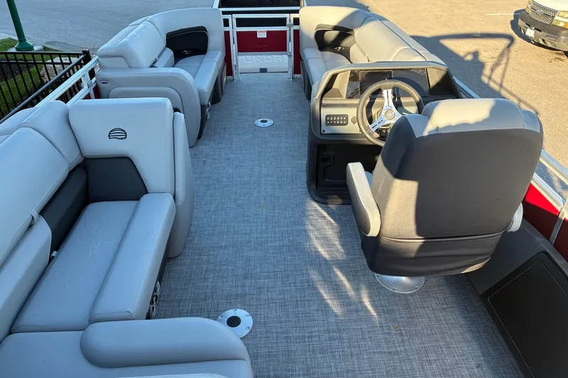 Slide: The Image of Interior of 2026 Sun Tracker SportFish 22 DLX pontoon boat with plush seating and steering console. - 14