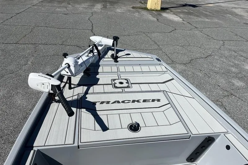 Slide: The Image of 2027 Tracker Bass Tracker Classic CC boat deck with trolling motor on pavement. - 13