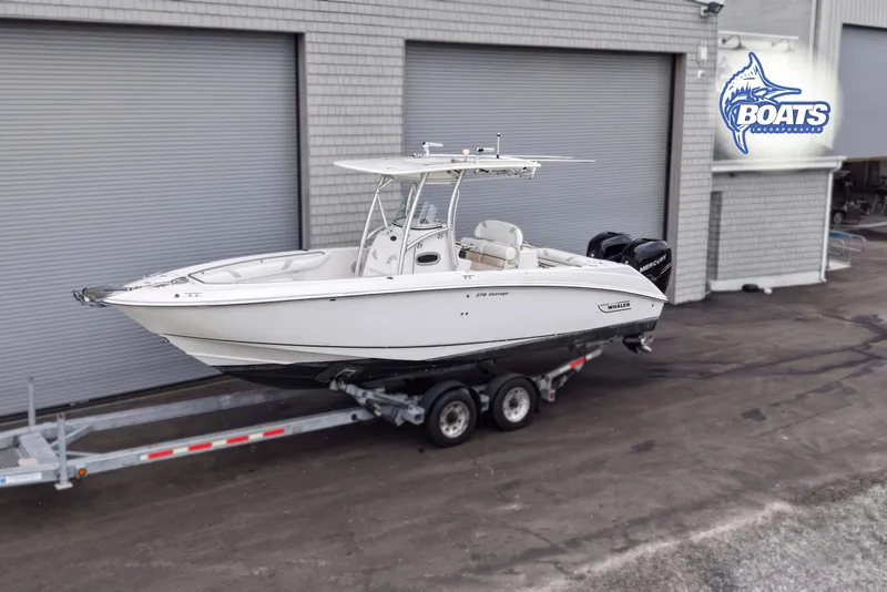 Slide: The Image of 2006 Boston Whaler 270 Outrage boat on trailer, parked near industrial building. - 1