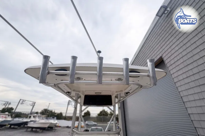 Slide: The Image of 2006 Boston Whaler 270 Outrage boat with rod holders, docked near a building. - 10