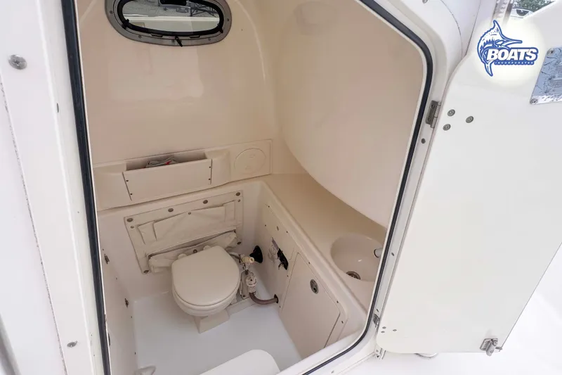 Slide: The Image of Interior of 2006 Boston Whaler 270 Outrage boat, featuring compact marine toilet. - 7