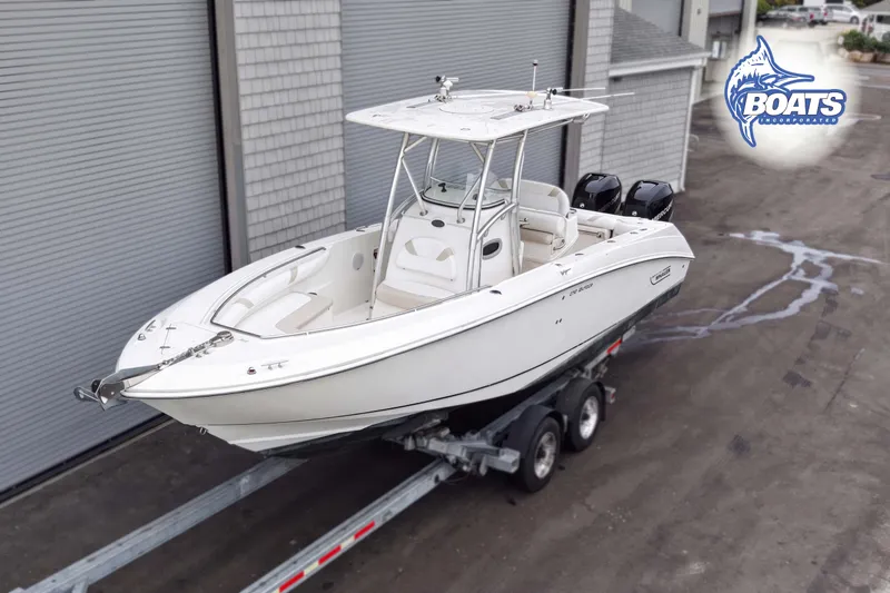 Slide: The Image of 2006 Boston Whaler 270 Outrage boat on trailer, parked near industrial building. - 2