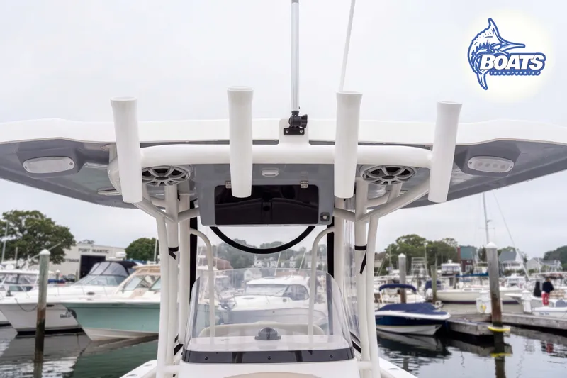 Slide: The Image of 2024 Parker 2300 Special Edition boat at marina, featuring rod holders and canopy. - 5