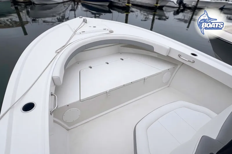 Slide: The Image of 2024 Parker 2300 Special Edition boat interior with seating and storage, docked at marina. - 3
