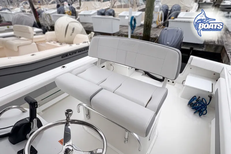 Slide: The Image of 2024 Parker 2300 Special Edition boat interior with steering wheel and seating at marina. - 7