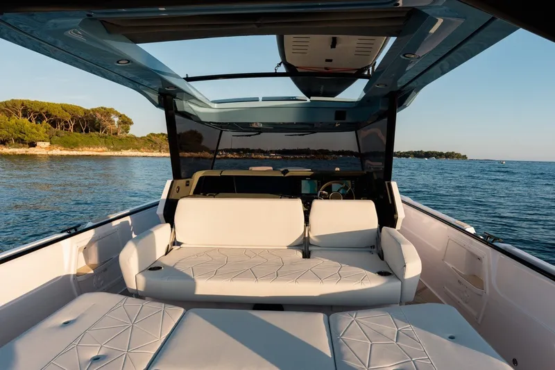 Slide: The Image of Luxurious 2027 Axopar 38 Cross Top boat interior with white seating, overlooking serene waters. - 17