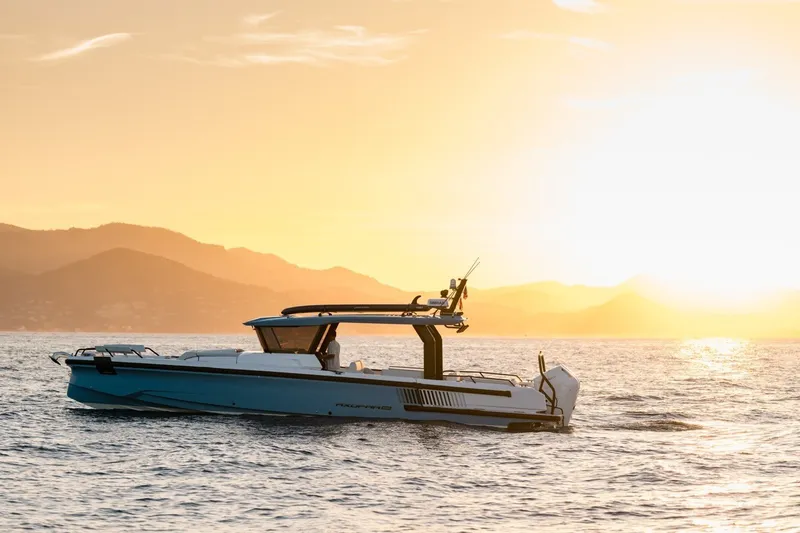 Slide: The Image of 2027 Axopar 38 Cross Top boat cruising at sunset on serene waters. - 19
