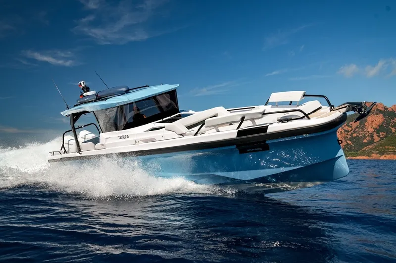 Slide: The Image of 2027 Axopar 38 Cross Top boat cruising on open water under clear blue skies. - 1