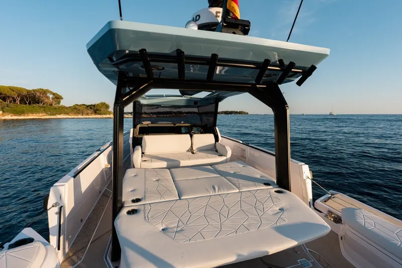 Slide: The Image of 2027 Axopar 38 Cross Top boat with spacious deck, cruising on serene waters. - 16