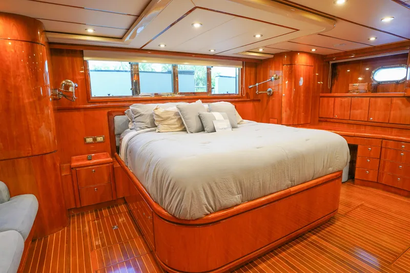 Slide: The Image of Luxurious Monte Fino 82MY 2001 yacht bedroom with wood paneling and plush bedding. - 35