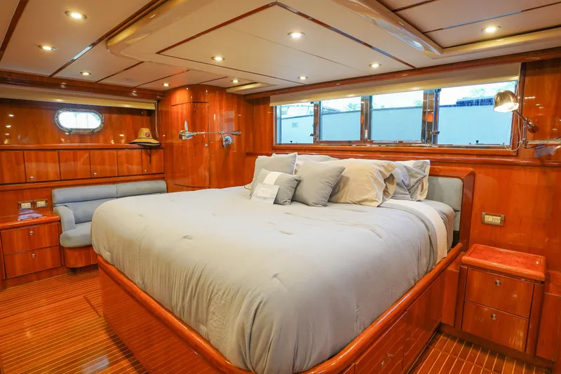 Slide: The Image of Luxurious Monte Fino 82MY 2001 yacht bedroom with wood paneling and plush bedding. - 37