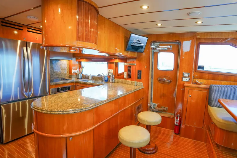 Slide: The Image of Luxurious 2001 Monte Fino 82MY yacht kitchen with wood cabinetry and granite countertops. - 27