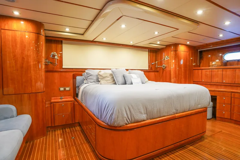 Slide: The Image of Luxurious Monte Fino 82MY 2001 yacht bedroom with elegant wood finish and plush bedding. - 36