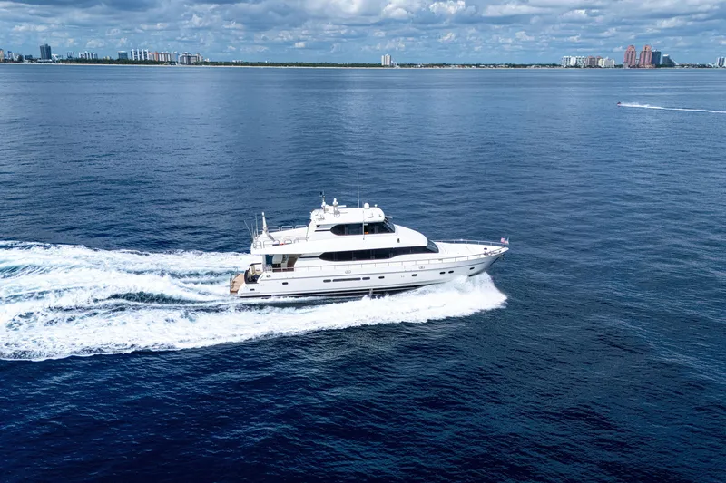 Slide: The Image of Luxurious 2001 Monte Fino 82MY yacht cruising on open sea with city skyline backdrop. - 2