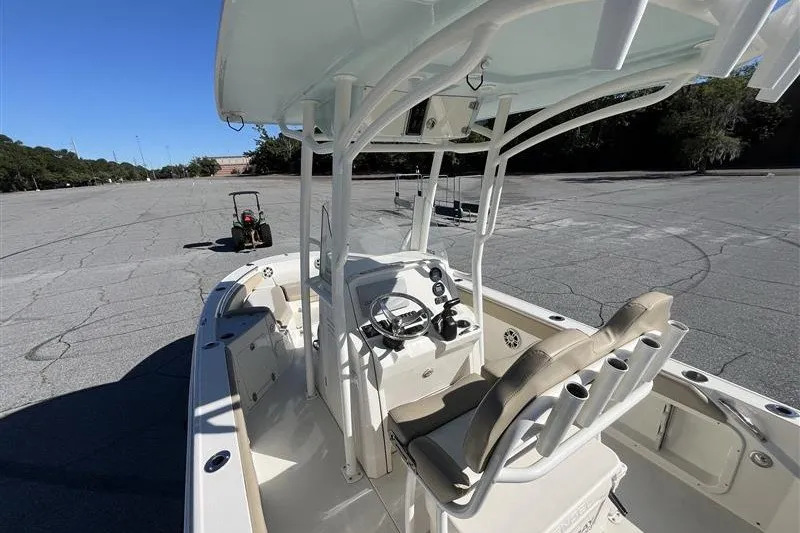 Slide: The Image of 2019 Stingray 236 CC boat with center console and seating, parked on pavement. - 10