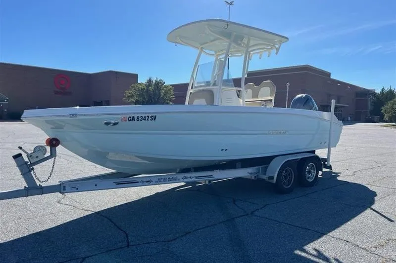 Slide: The Image of 2019 Stingray 236 CC boat on trailer in parking lot, sunny day. - 0