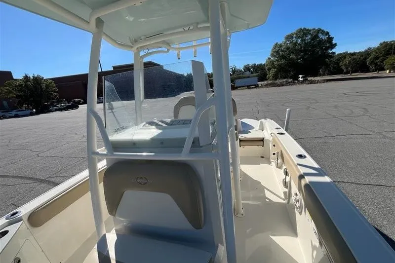 Slide: The Image of 2019 Stingray 236 CC boat with center console and T-top in a parking lot. - 6