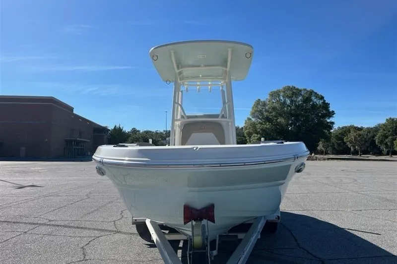Slide: The Image of 2019 Stingray 236 CC boat on trailer, parked outdoors under clear blue sky. - 4