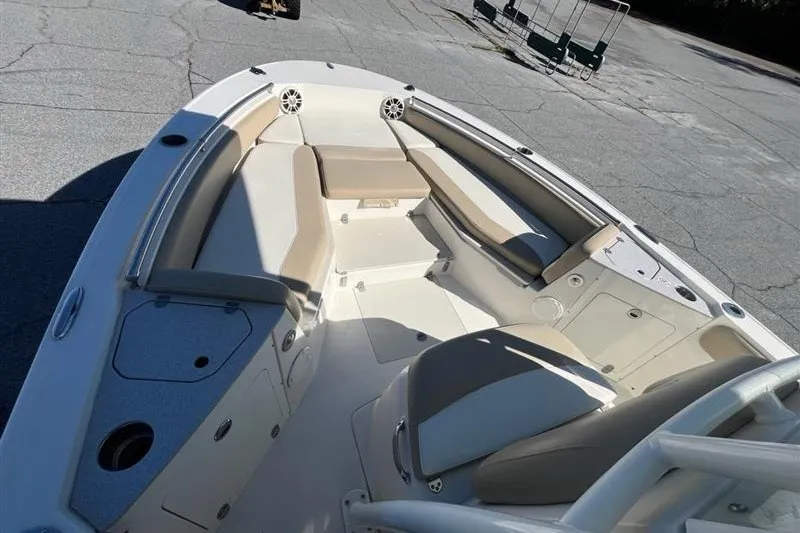 Slide: The Image of 2019 Stingray 236 CC boat interior with beige seating and storage compartments. - 8
