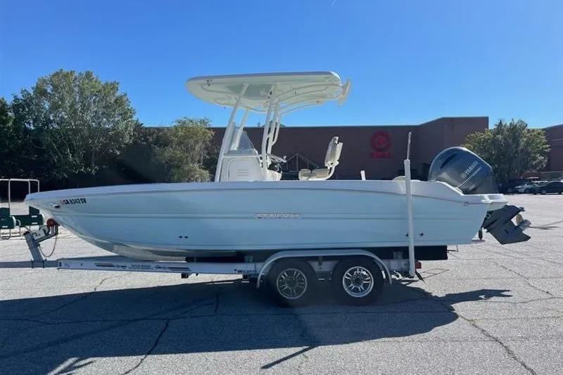 Slide: The Image of 2019 Stingray 236 CC boat on trailer in parking lot, sunny day. - 1