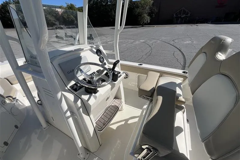 Slide: The Image of 2019 Stingray 236 CC boat interior with steering console and seating. - 11