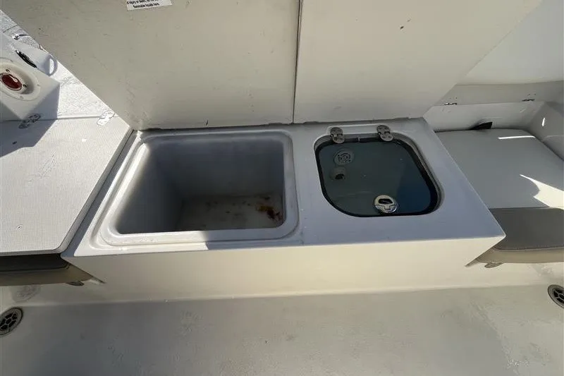 Slide: The Image of 2019 Stingray 236 CC boat interior with storage compartments and seating. - 9