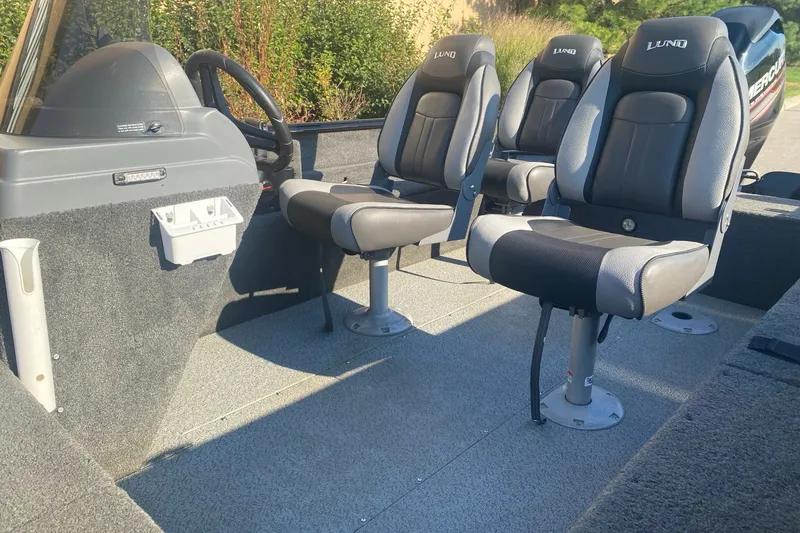Slide: The Image of 2014 Lund 1650 Rebel XL SS boat interior with three cushioned seats and steering console. - 13