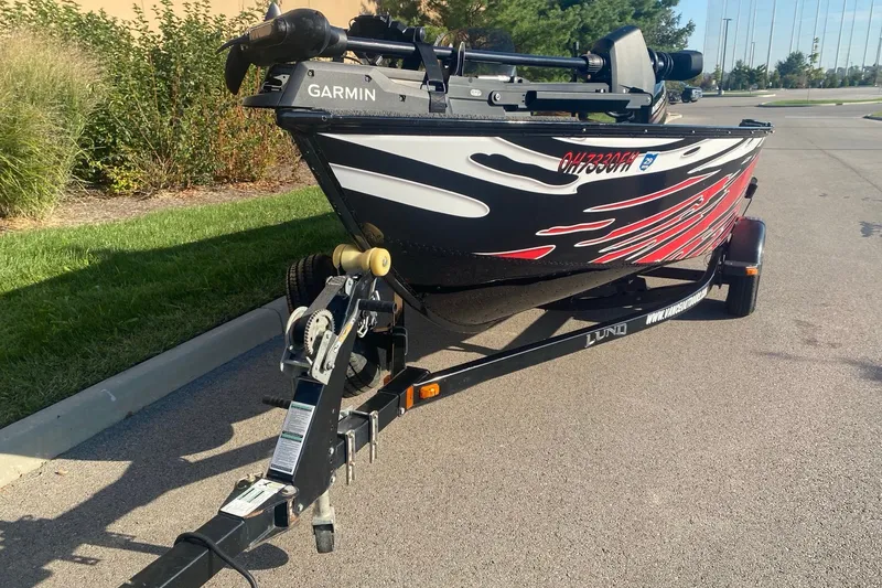 Slide: The Image of 2014 Lund 1650 Rebel XL SS boat on trailer with Garmin equipment, parked outdoors. - 2