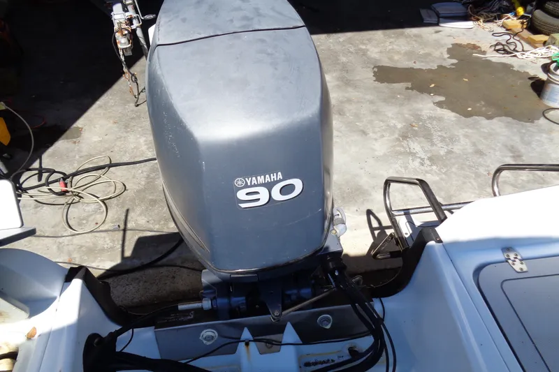 Slide: The Image of 2004 Triumph 190 Bay boat with Yamaha 90 outboard motor in a garage setting. - 12