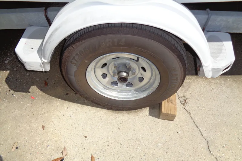 Slide: The Image of Trailer wheel of a 2004 Triumph 190 Bay, supported by a wooden block. - 16